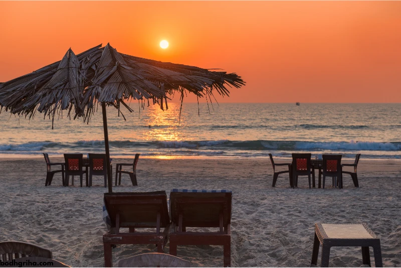 sunset on the beach with chairs and umbrellas on the
