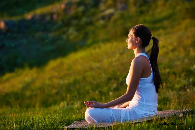 woman sitting in a yoga position on a blanket in